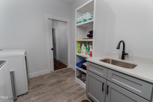 laundry area featuring cabinets, sink, and washer and clothes dryer