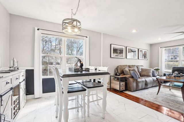 dining space with ceiling fan with notable chandelier