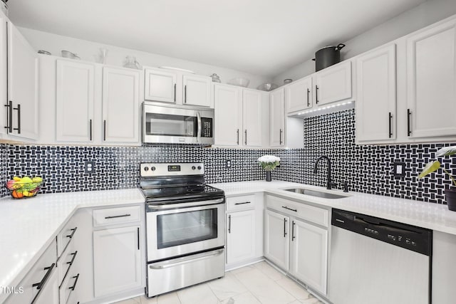 kitchen with sink, backsplash, white cabinets, and stainless steel appliances