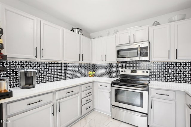 kitchen with backsplash, white cabinets, and stainless steel appliances