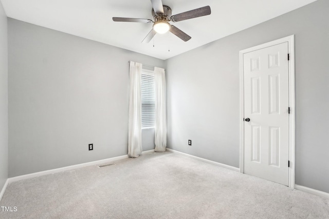 spare room with ceiling fan and light carpet