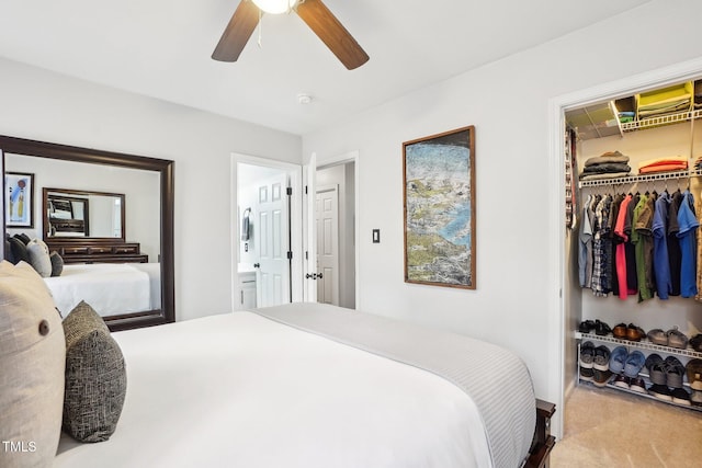 bedroom featuring ceiling fan, light carpet, a spacious closet, and a closet