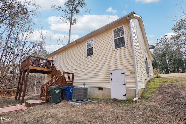 rear view of property featuring a wooden deck and cooling unit