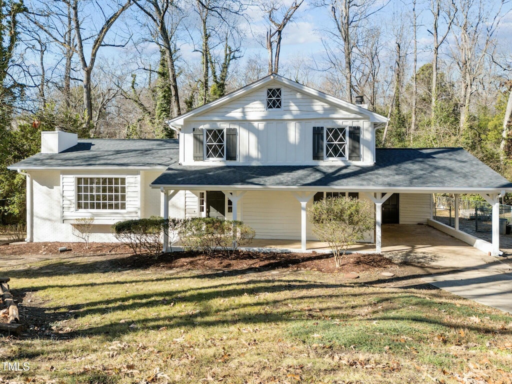 view of front of property featuring a front lawn and a carport