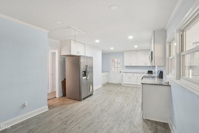 kitchen with ornamental molding, stainless steel appliances, light stone countertops, light hardwood / wood-style floors, and white cabinets