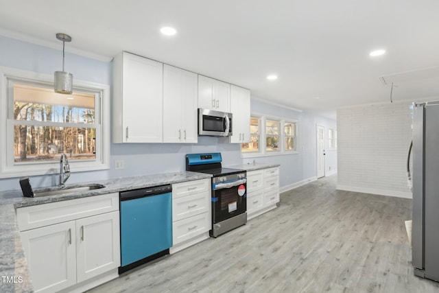 kitchen with sink, white cabinetry, hanging light fixtures, stainless steel appliances, and light stone countertops