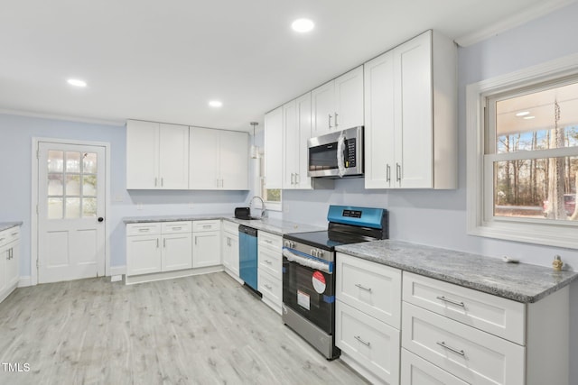 kitchen with white cabinetry, appliances with stainless steel finishes, sink, and light hardwood / wood-style flooring