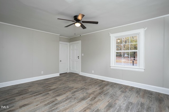 spare room with baseboards, wood finished floors, a ceiling fan, and crown molding