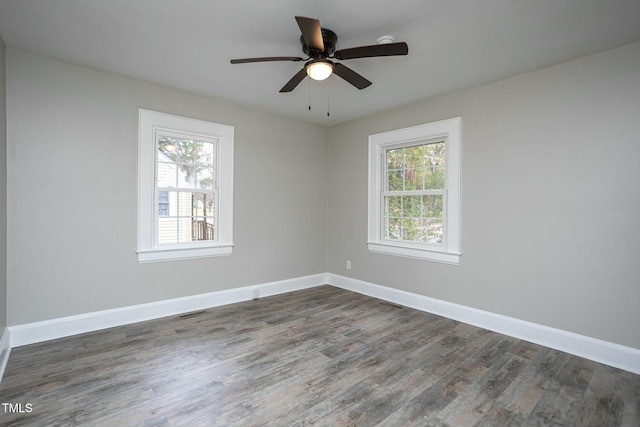 empty room with a ceiling fan, dark wood-style flooring, and baseboards