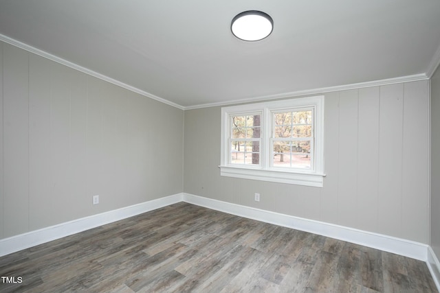 spare room featuring ornamental molding, dark wood-type flooring, and baseboards