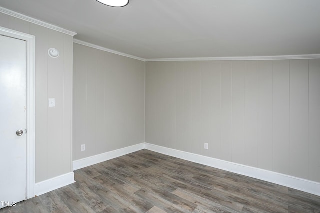 spare room featuring baseboards, dark wood finished floors, and crown molding