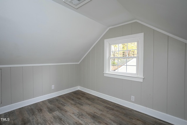 additional living space featuring vaulted ceiling, dark wood-style flooring, and visible vents