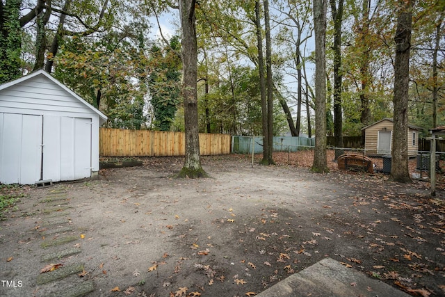 view of yard featuring an outbuilding, a fenced backyard, and a shed