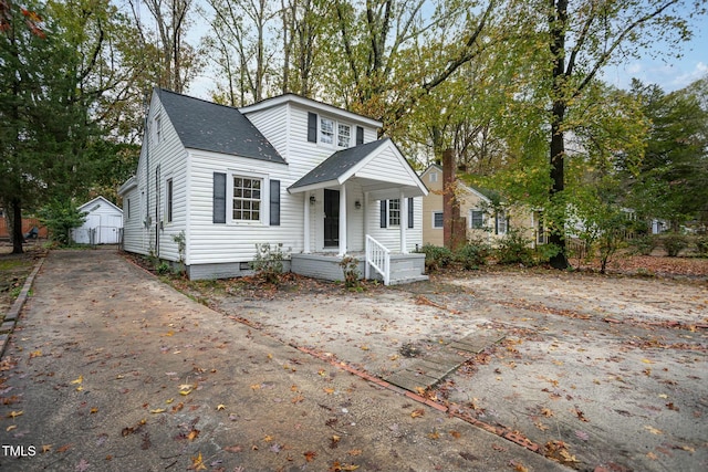 view of front facade with roof with shingles and crawl space