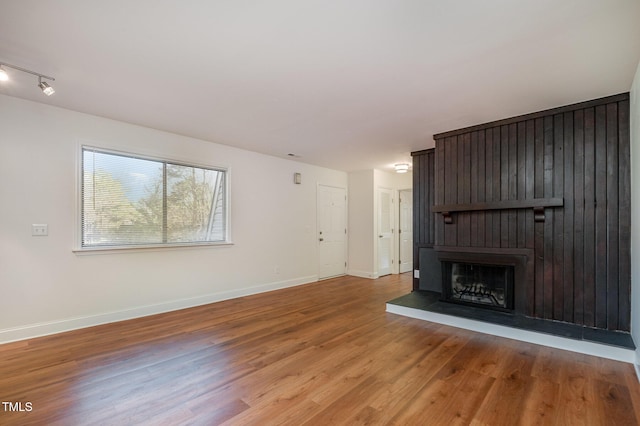 unfurnished living room featuring a large fireplace and light hardwood / wood-style floors