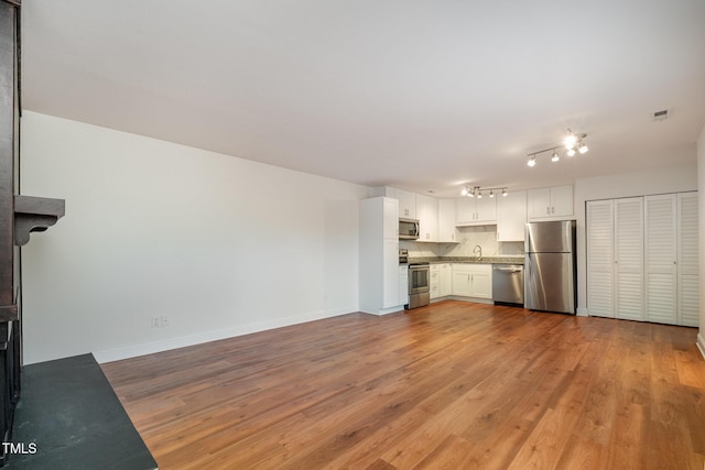 unfurnished living room with light hardwood / wood-style floors and sink