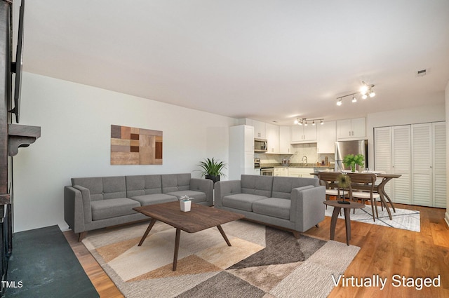 living room featuring sink and light wood-type flooring