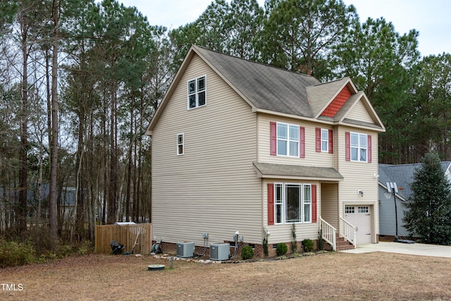 view of front of home featuring a garage, central AC unit, and a front yard