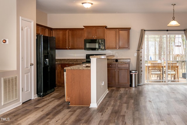 kitchen featuring dark stone counters, decorative light fixtures, dark hardwood / wood-style flooring, and black appliances