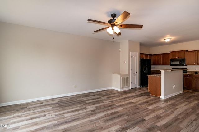 kitchen with ceiling fan, a center island, hardwood / wood-style floors, and black appliances