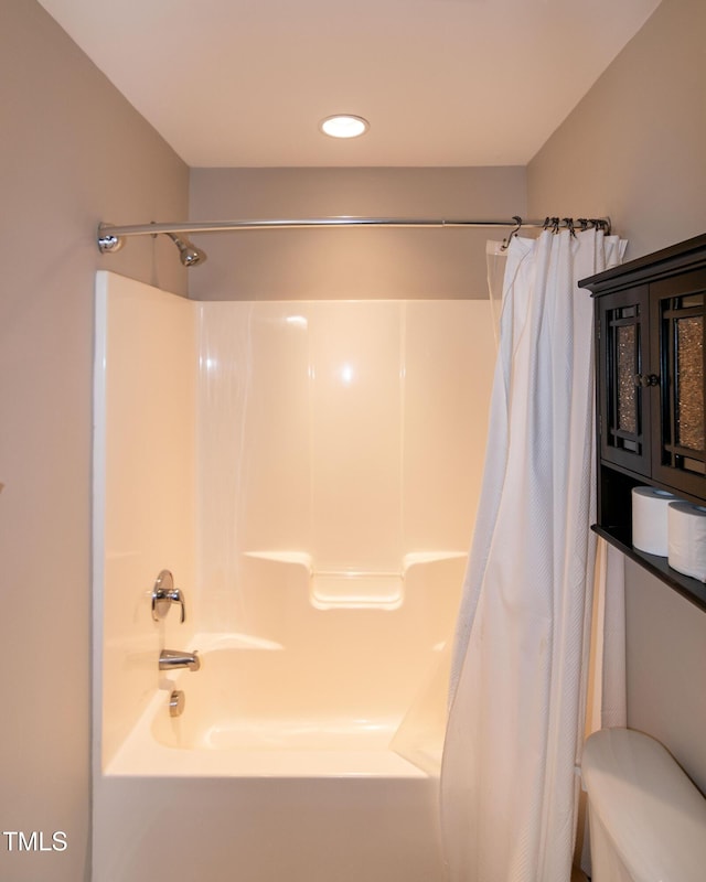 bathroom with shower / bath combination with curtain and toilet