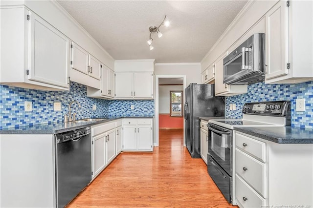 kitchen with black appliances, white cabinets, backsplash, and sink