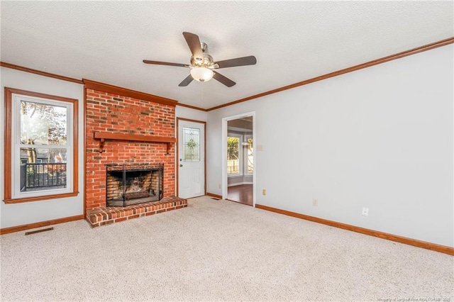 unfurnished living room with crown molding, carpet floors, ceiling fan, a brick fireplace, and a textured ceiling