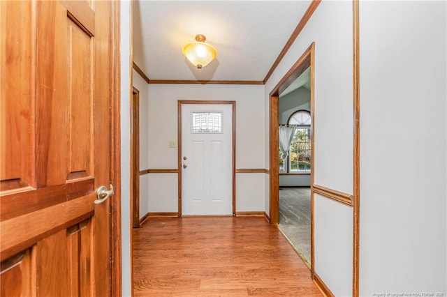 entryway featuring ornamental molding and light hardwood / wood-style floors