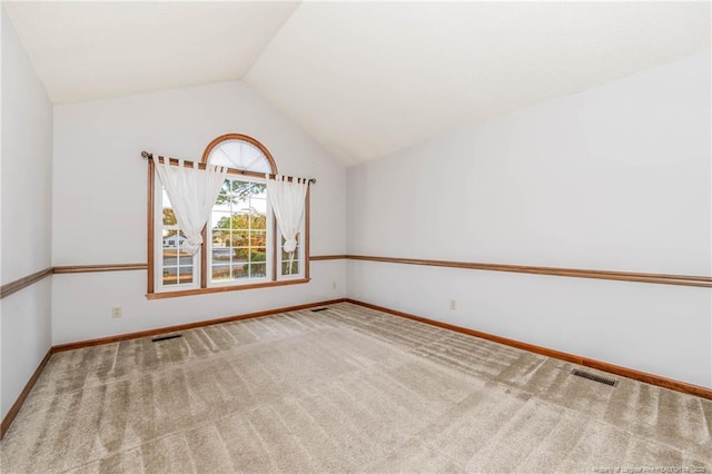 unfurnished room with carpet floors and vaulted ceiling