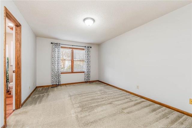 carpeted spare room with a textured ceiling