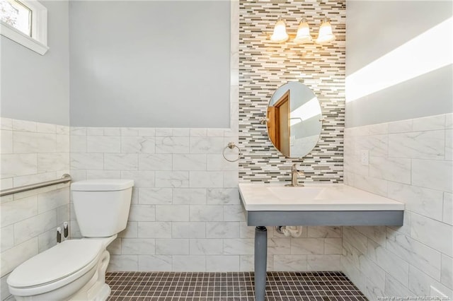 bathroom featuring toilet and tile walls