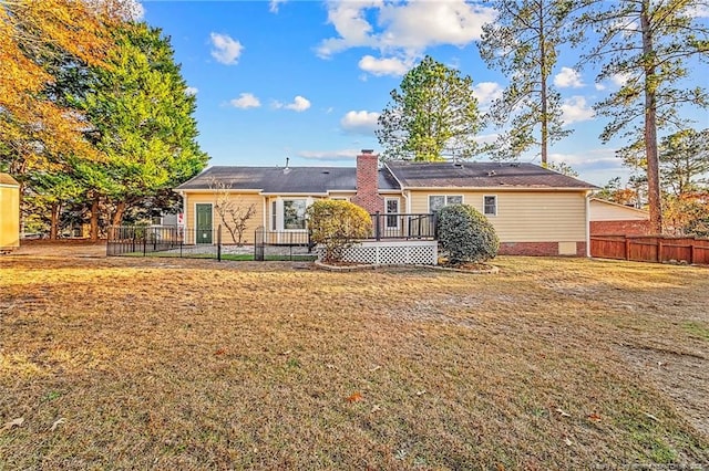 back of house with a deck and a yard