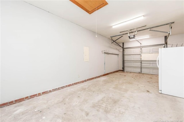 garage featuring white refrigerator and a garage door opener