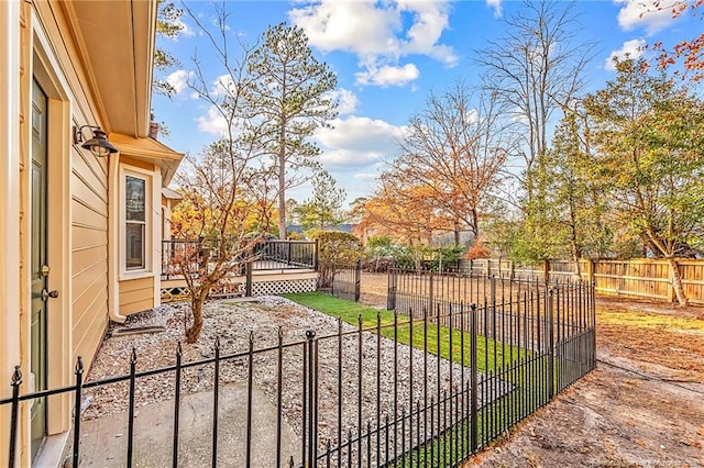 view of gate featuring a deck, a yard, and a patio area