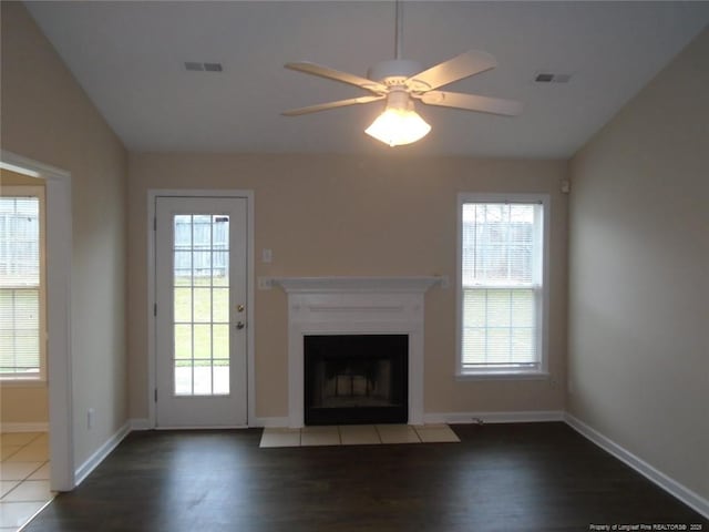 unfurnished living room with lofted ceiling, hardwood / wood-style floors, ceiling fan, and a healthy amount of sunlight