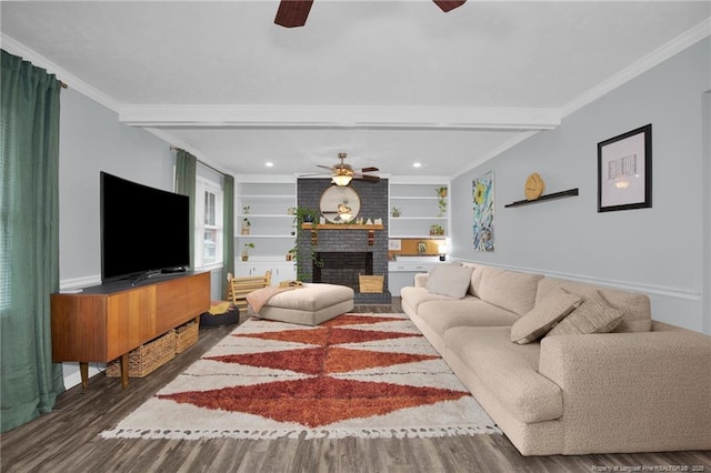 living room featuring wood-type flooring, built in shelves, ornamental molding, and a fireplace