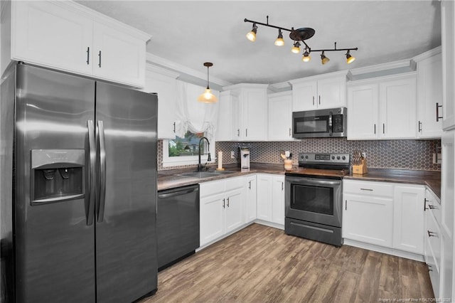 kitchen with decorative backsplash, sink, white cabinets, and appliances with stainless steel finishes