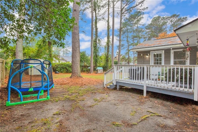 view of yard featuring a deck and a trampoline