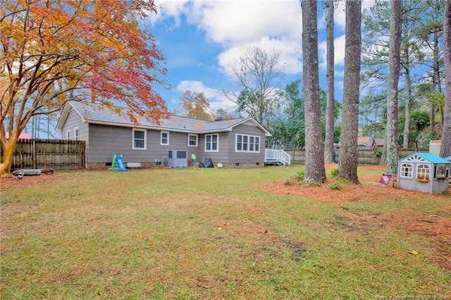 back of house featuring a lawn and cooling unit