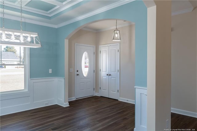 foyer entrance featuring a wealth of natural light, crown molding, and dark hardwood / wood-style floors