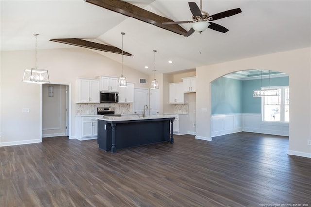 kitchen with stainless steel appliances, a center island with sink, tasteful backsplash, and white cabinetry