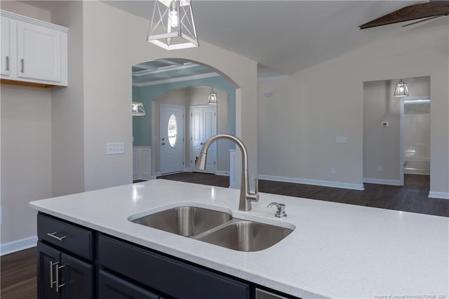 kitchen featuring pendant lighting, dark hardwood / wood-style flooring, white cabinetry, ceiling fan, and sink