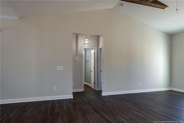 spare room with dark hardwood / wood-style flooring and vaulted ceiling