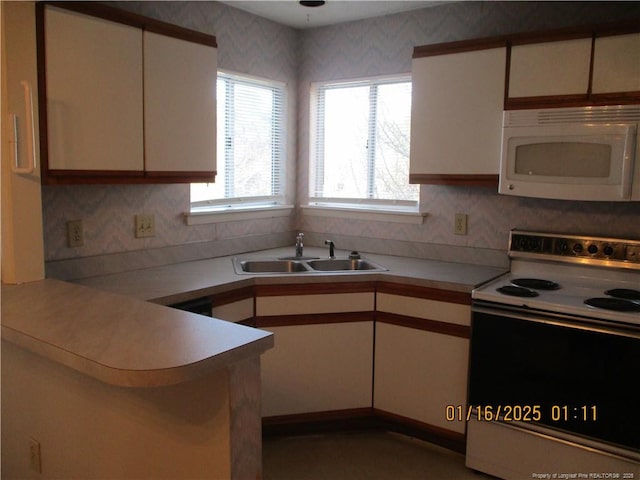 kitchen featuring range with electric stovetop, white cabinets, and sink