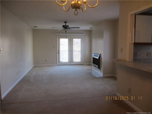 unfurnished living room featuring ceiling fan with notable chandelier, light colored carpet, and heating unit