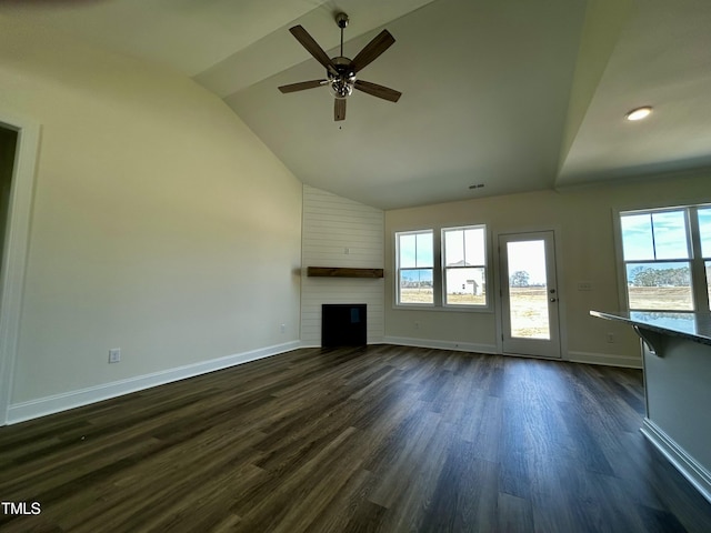 unfurnished living room featuring dark wood-style flooring, a large fireplace, ceiling fan, high vaulted ceiling, and baseboards