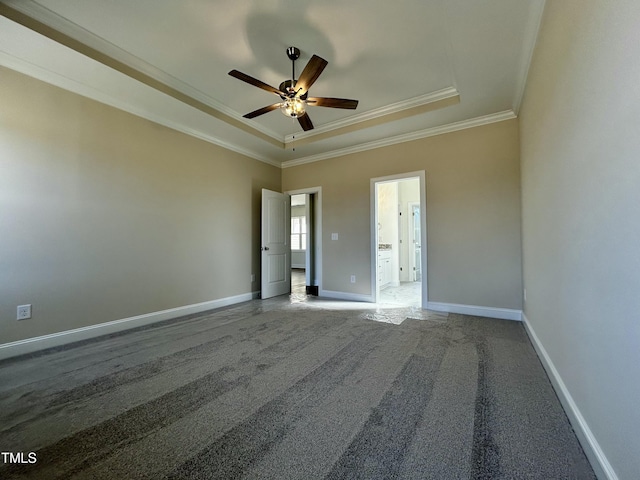 spare room featuring ceiling fan, carpet flooring, baseboards, a raised ceiling, and crown molding