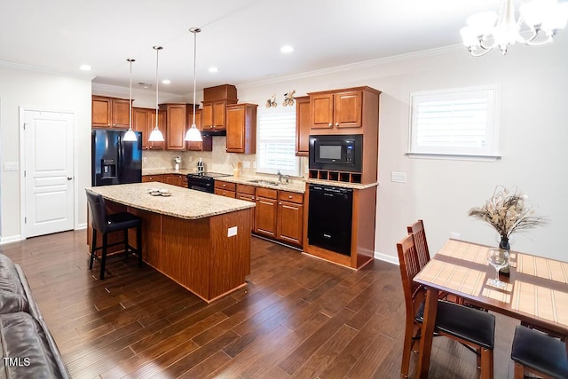 kitchen featuring pendant lighting, tasteful backsplash, a chandelier, a center island, and black appliances