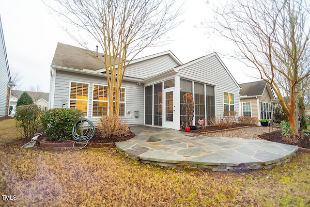 rear view of house featuring a sunroom