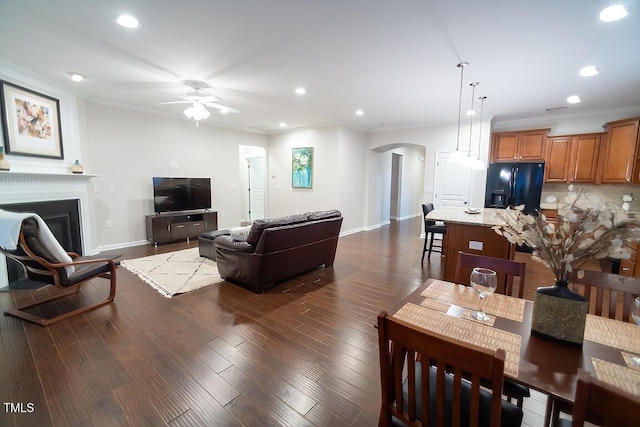 living room with crown molding, ceiling fan, and dark hardwood / wood-style floors